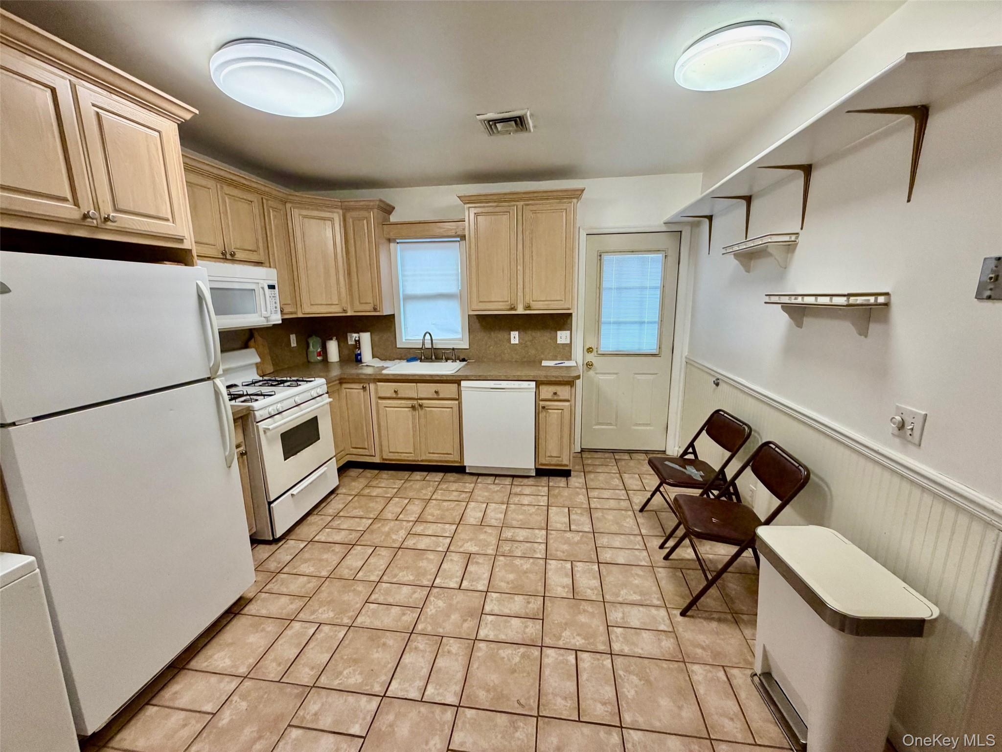 16 November Walk Long Beach, NY 11561 - Photo 6 of 11 a kitchen with a sink a stove and white cabinets