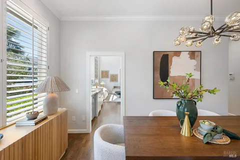 a dining room with chandelier and wooden floor