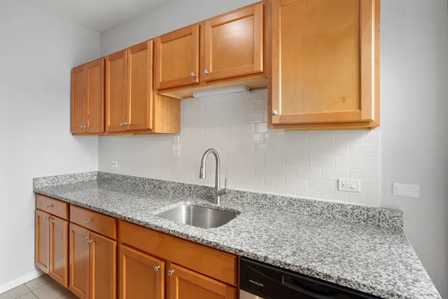 a kitchen with granite countertop a sink and cabinets