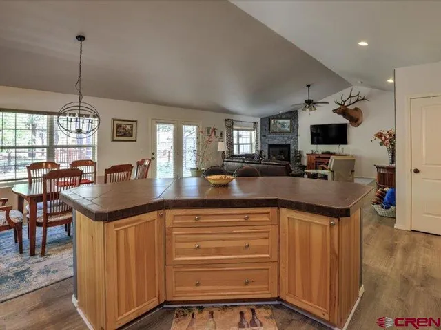 a kitchen with stainless steel appliances granite countertop a stove refrigerator and dining table with wooden floor