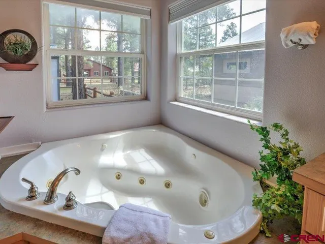 a white bath tub sitting in a bathroom next to a window