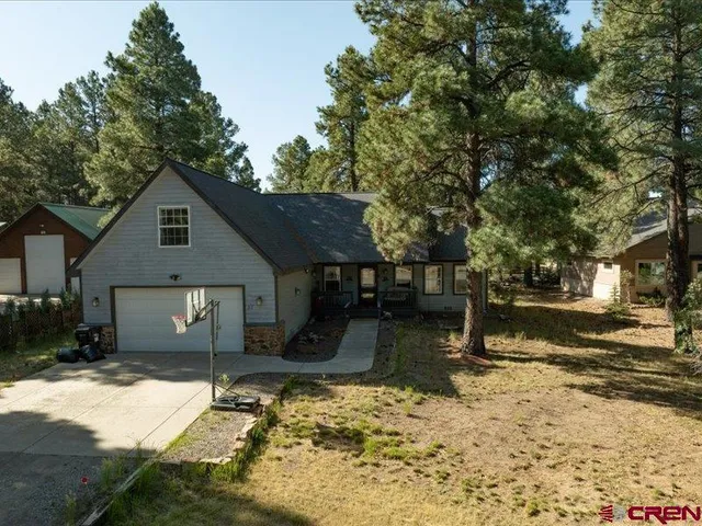 a front view of a house with a yard covered with snow