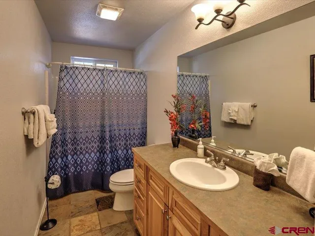 a bathroom with a sink vanity mirror and toilet