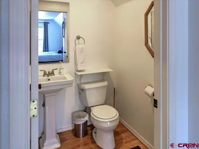 a bathroom with a toilet a sink and mirror