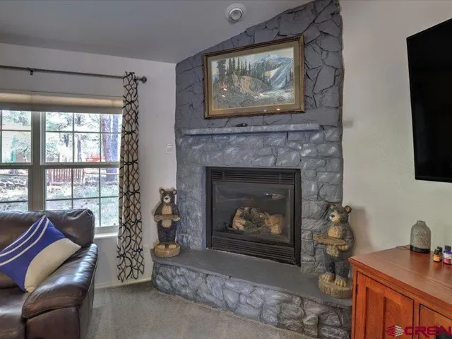 a living room with furniture a flat screen tv and a fireplace