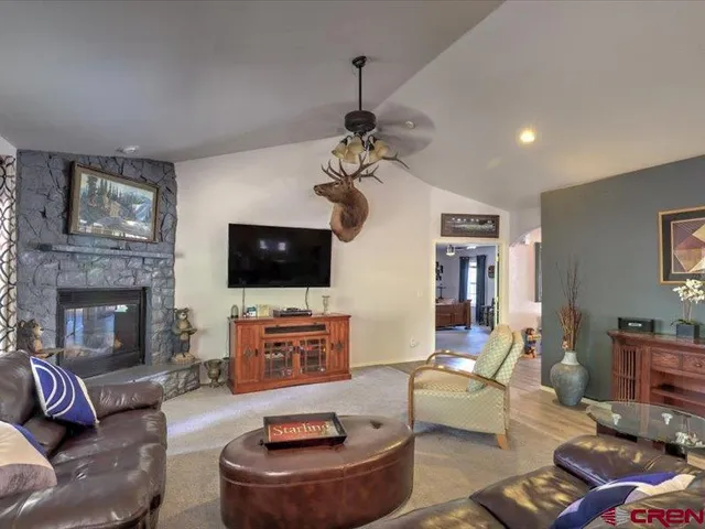 a living room with furniture a flat screen tv and a fireplace