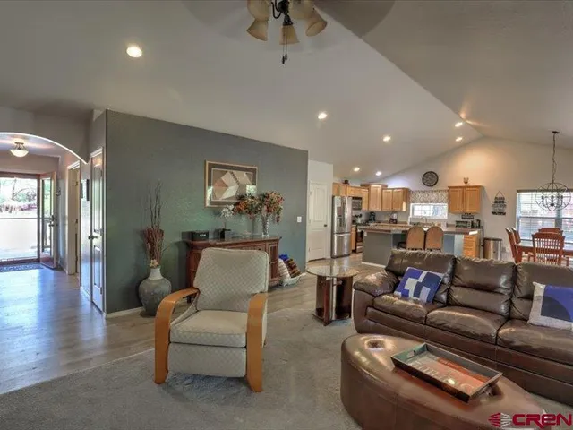 a living room with furniture and a view of kitchen