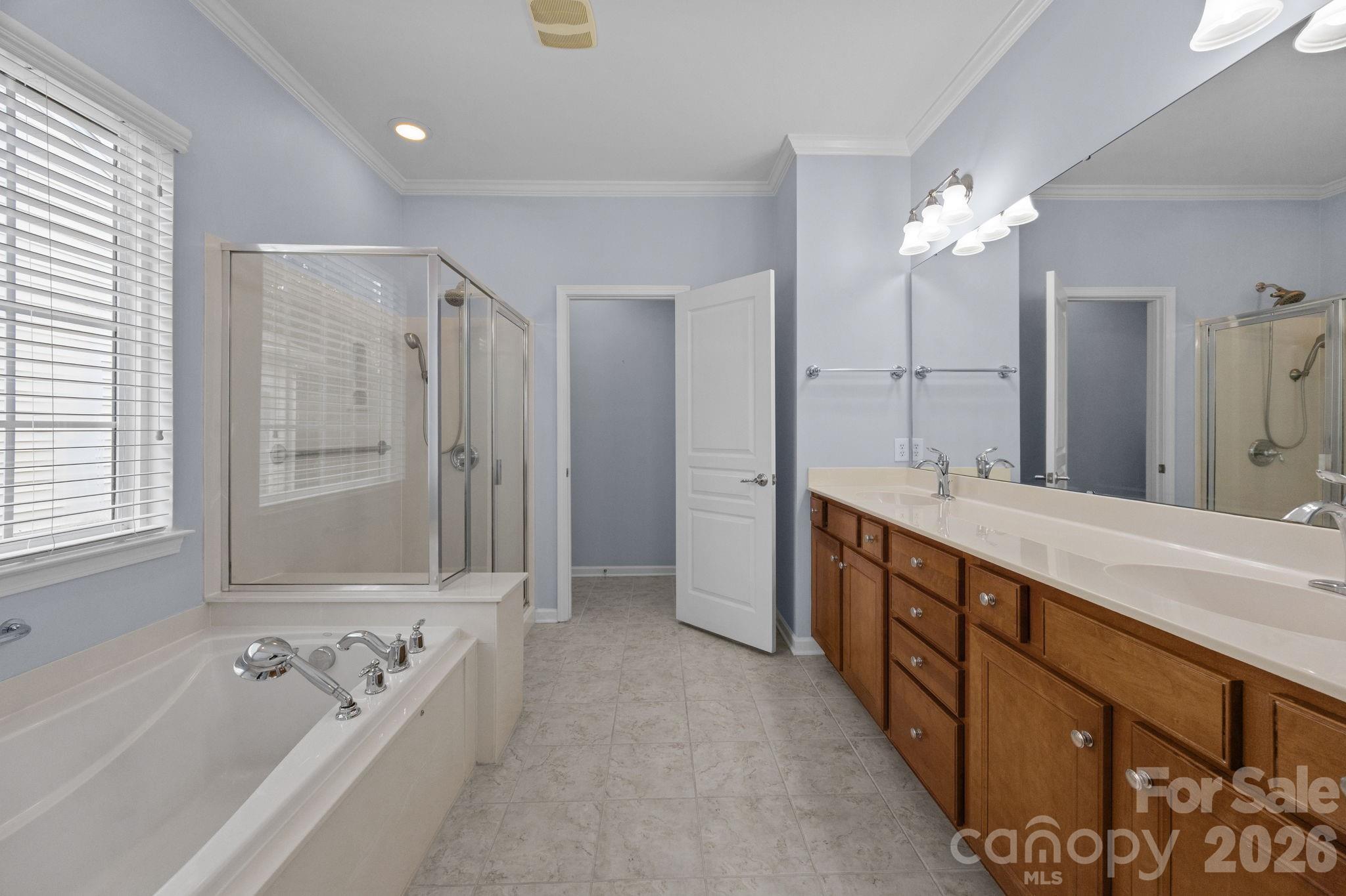 52062 Longspur Lane Fort Mill, SC 29707 - Photo 19 of 31 a bathroom with a tub a double vanity sink and mirror