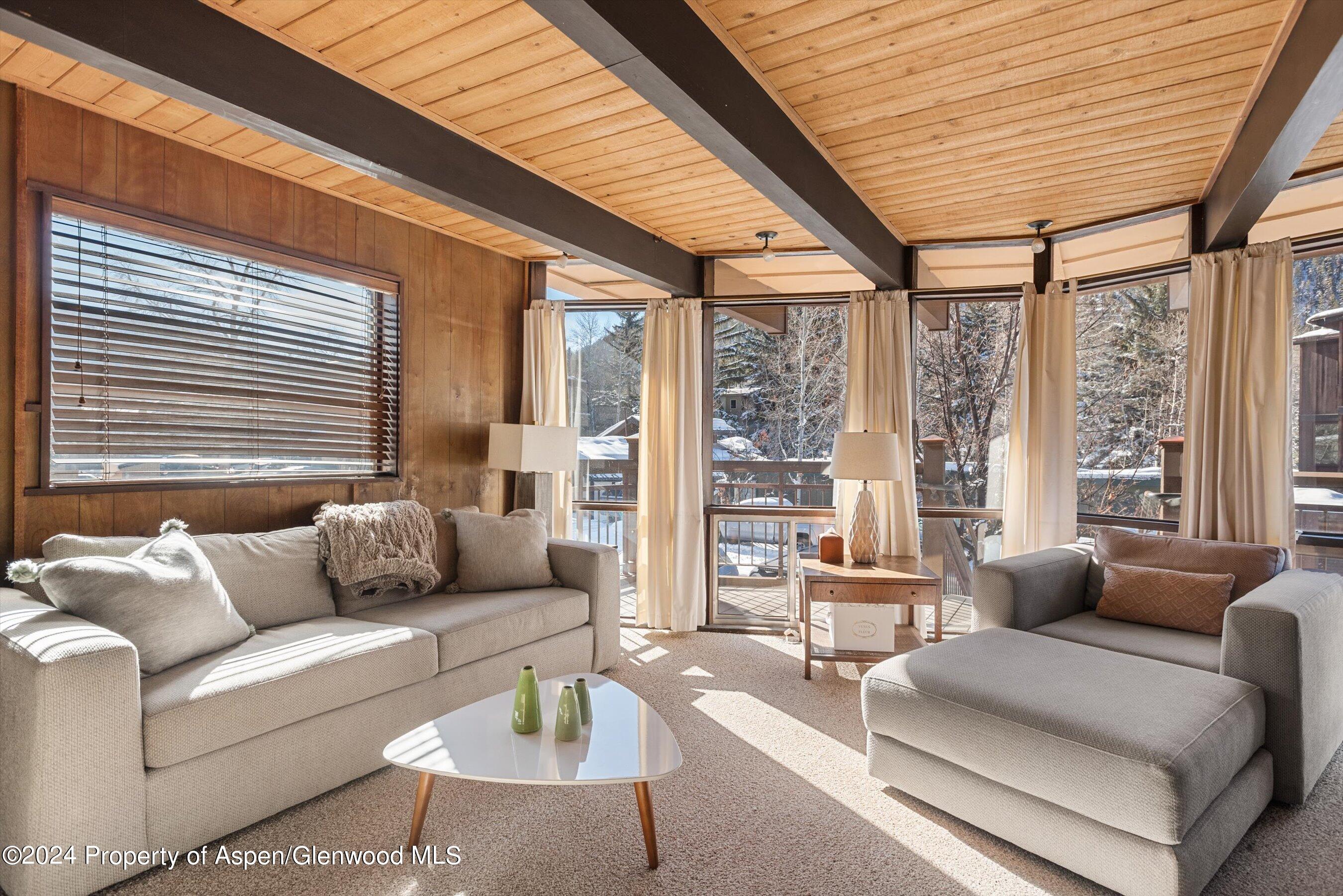 a living room with furniture and floor to ceiling windows