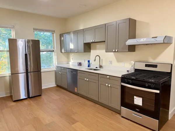 a kitchen with stainless steel appliances a stove a sink and a refrigerator