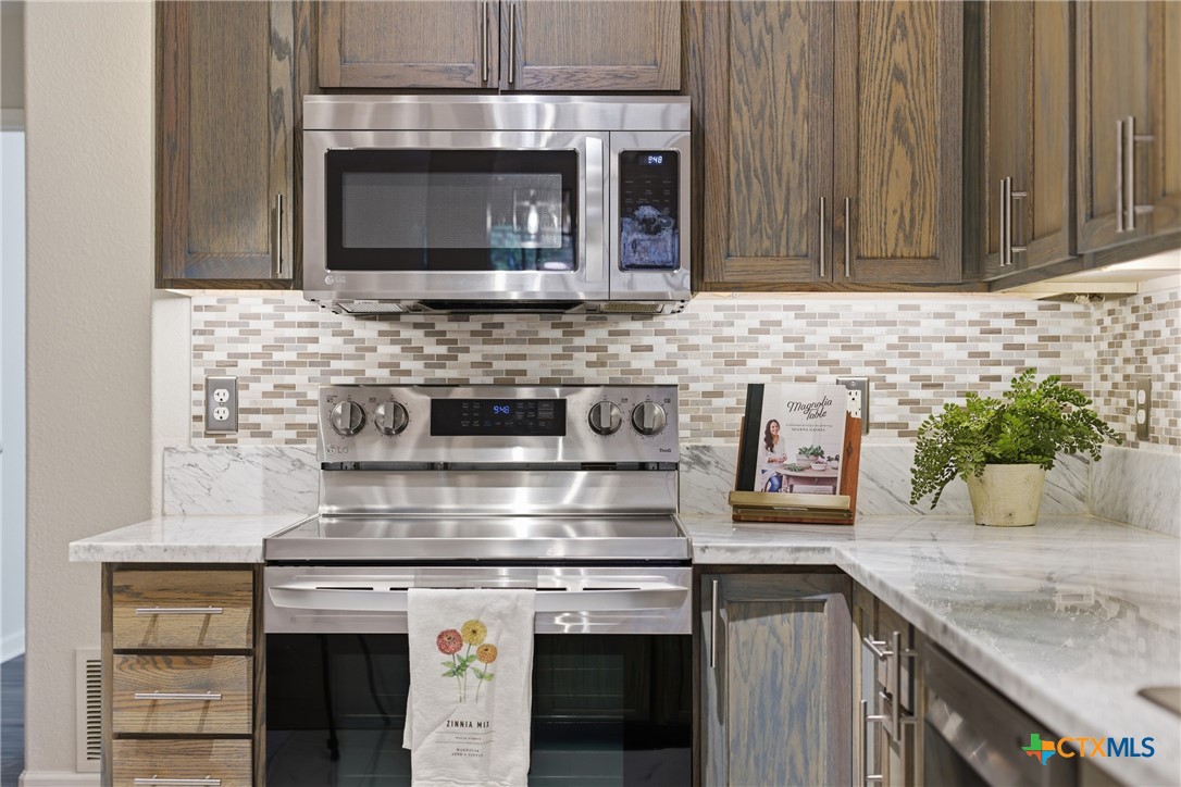658 Devin Drive Temple, TX 76502 - Photo 12 of 30 a kitchen with granite countertop a stove top oven microwave and cabinets