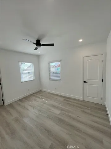an empty room with windows and cabinet