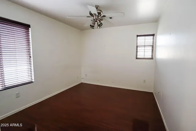 an empty room with a window and a fan
