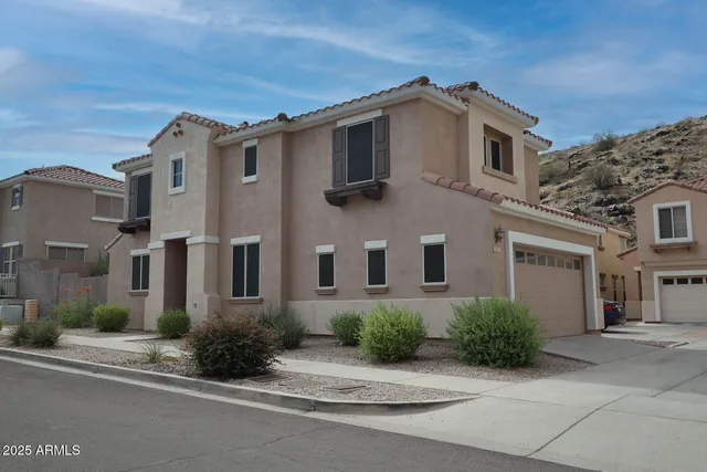 a front view of a house with yard and parking