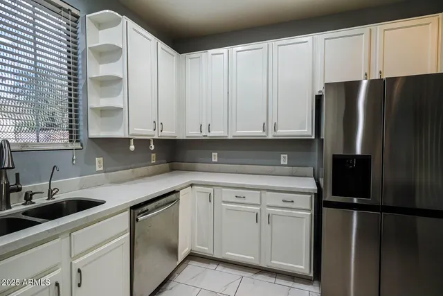 a kitchen with white cabinets and refrigerator