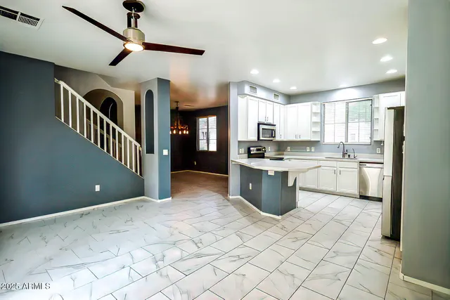 a kitchen with stainless steel appliances granite countertop a stove a sink a refrigerator and cabinets