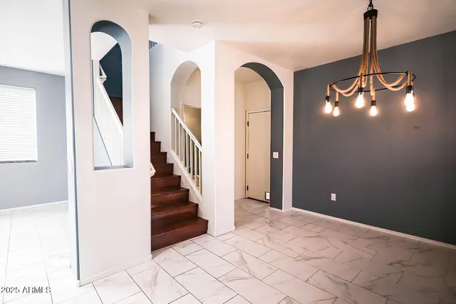 a view of a hallway with entryway and stairs