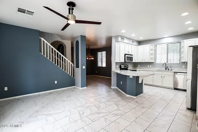 a kitchen with stainless steel appliances kitchen island granite countertop a sink a counter top space cabinets and a window