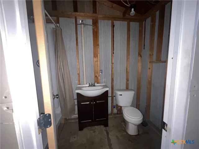 an empty room with ceiling fan and window