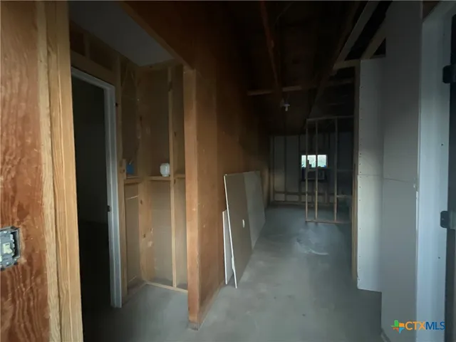 a view of a hallway with dining area and chandelier