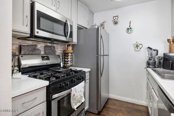 a kitchen with stainless steel appliances granite countertop a refrigerator and a stove top oven