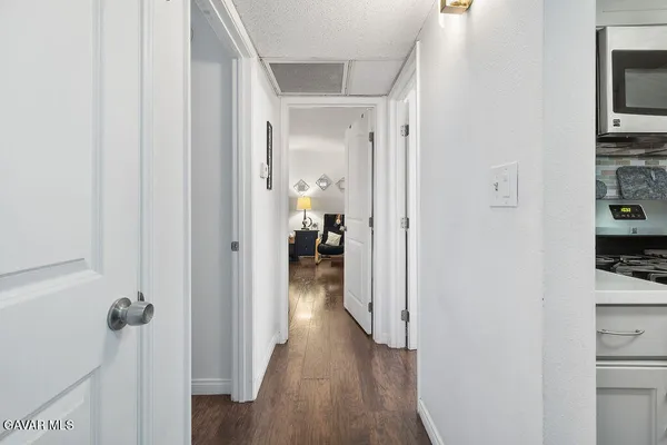 a view of a hallway with wooden floor and a living room