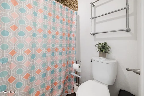 a white toilet sitting next to a shower curtain