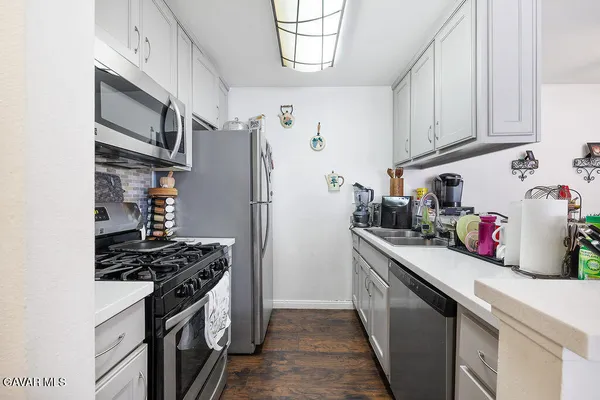 a kitchen with stainless steel appliances granite countertop a refrigerator stove and sink