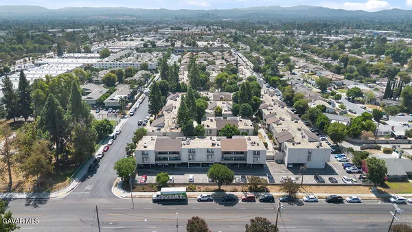 an aerial view of multiple houses with a city street