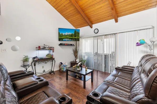 a living room with furniture a flat screen tv and a large window