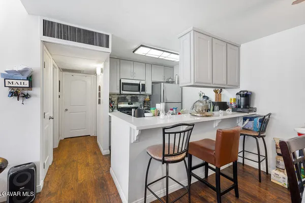 a kitchen with stainless steel appliances granite countertop a stove a sink a microwave and a refrigerator