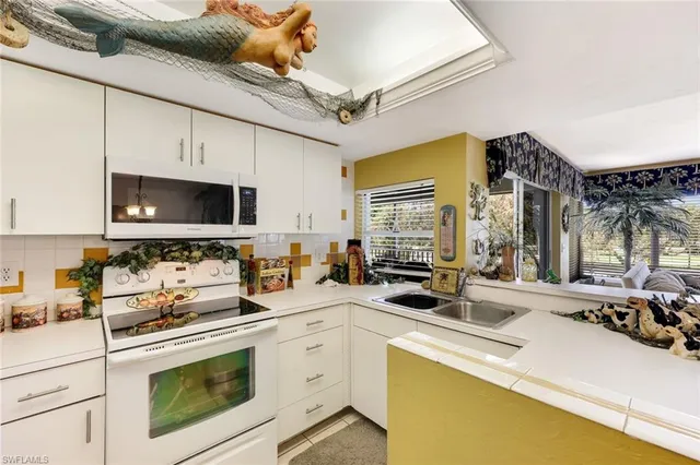 a kitchen with stainless steel appliances a stove a sink and a microwave