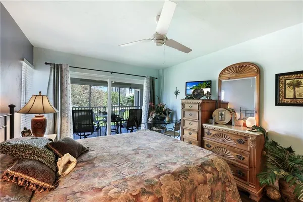 a bedroom with a bed and large windows