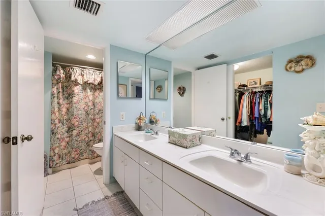 a bathroom with double vanity sinks a shower and a mirror