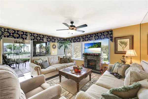 a living room with furniture a fireplace and a large window