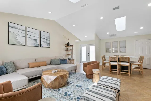 a dining hall with stainless steel appliances kitchen island granite countertop a dining table chairs and granite counter tops