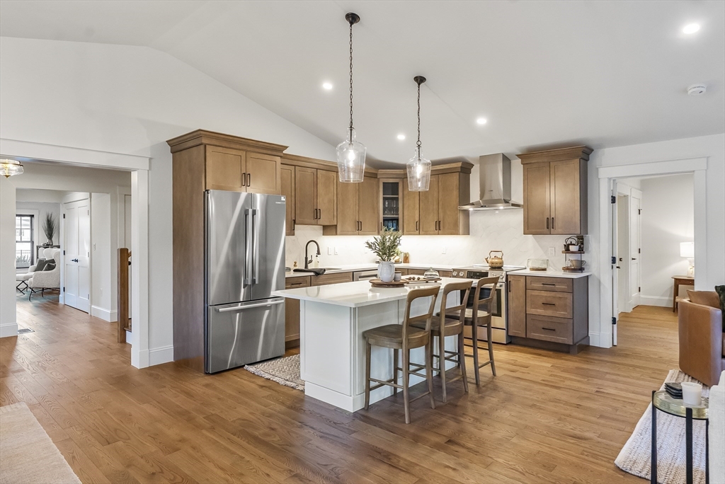 46 Sandwich Road, Unit 39 Plymouth, MA 02360 - Photo 12 of 41 a kitchen with stainless steel appliances a refrigerator a stove a sink dishwasher and a dining table with wooden floor