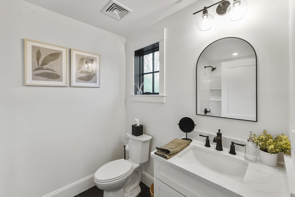 46 Sandwich Road, Unit 39 Plymouth, MA 02360 - Photo 33 of 41 a bathroom with a toilet sink mirror and vanity