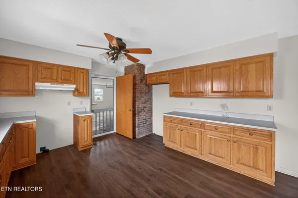 a kitchen with wooden floors and refrigerator
