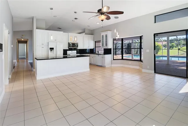 a large white kitchen with a large window cabinets and stainless steel appliances