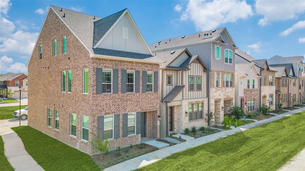 a view of residential houses with yard and plants
