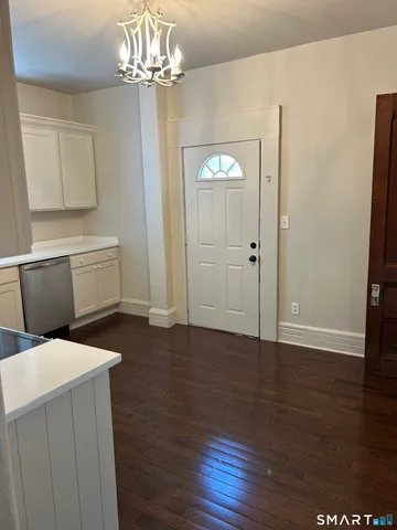 a room with a chandelier and wooden floor