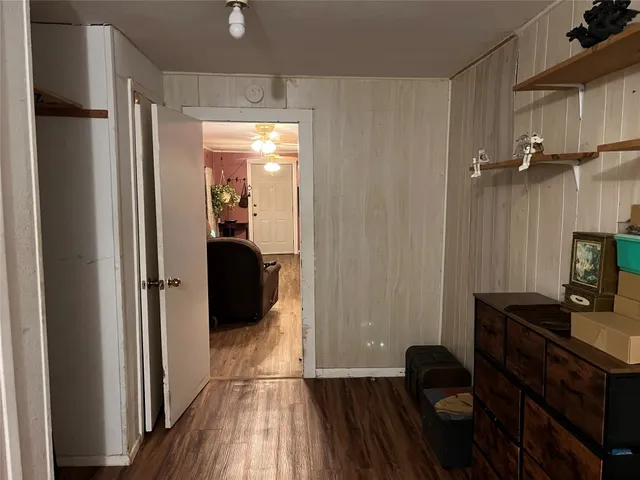 a walk in closet with wooden floor