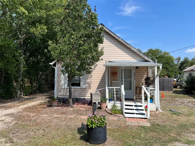 a view of house with patio outdoor seating and covered with trees