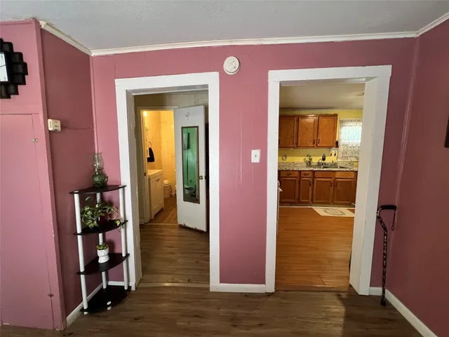 a view of hallway with livingroom and wooden floor