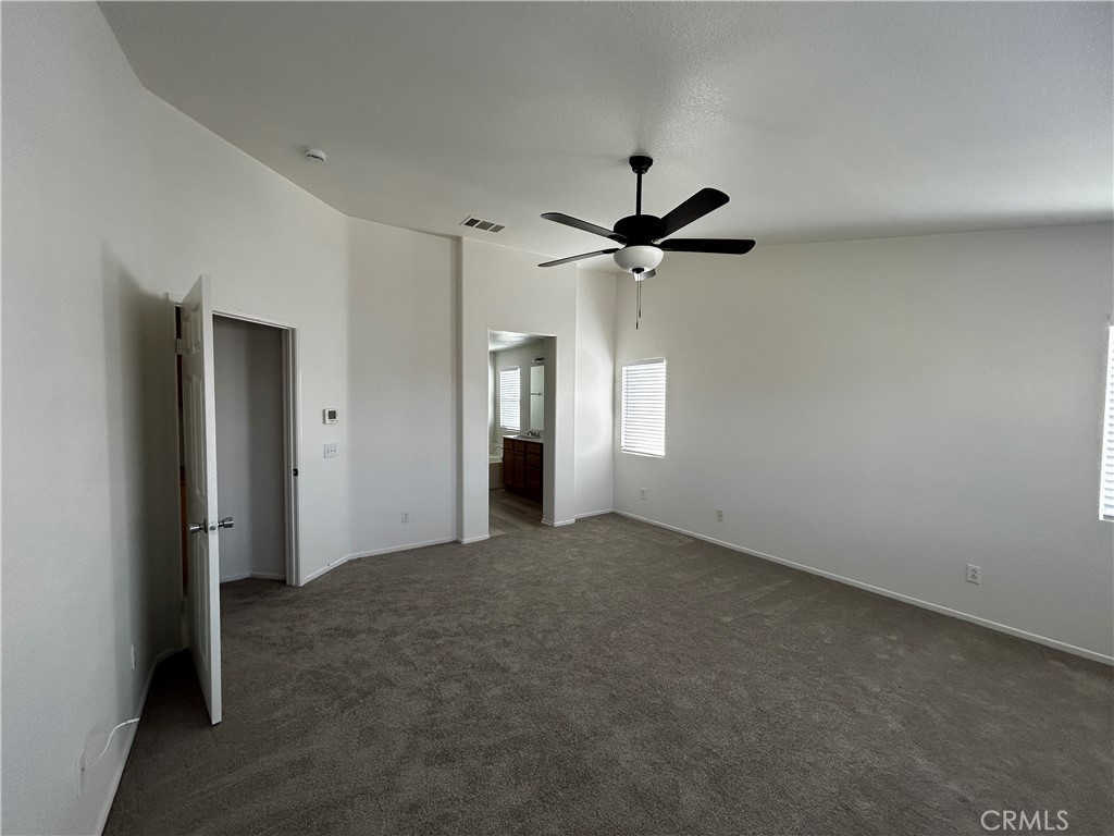 4210 Cloudywing Road Hemet, CA 92545 - Photo 15 of 27 an empty room with chandelier fan and windows