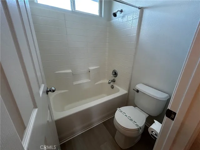 a white toilet sitting next to a bath tub
