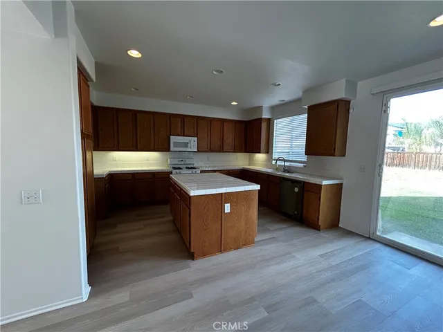a kitchen with stainless steel appliances kitchen island granite countertop a stove a sink and a refrigerator