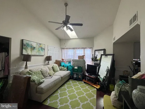 a living room with furniture a ceiling fan and a rug