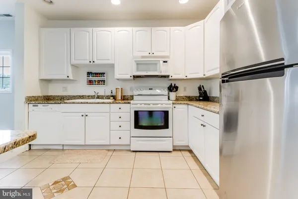a kitchen with white cabinets and white appliances